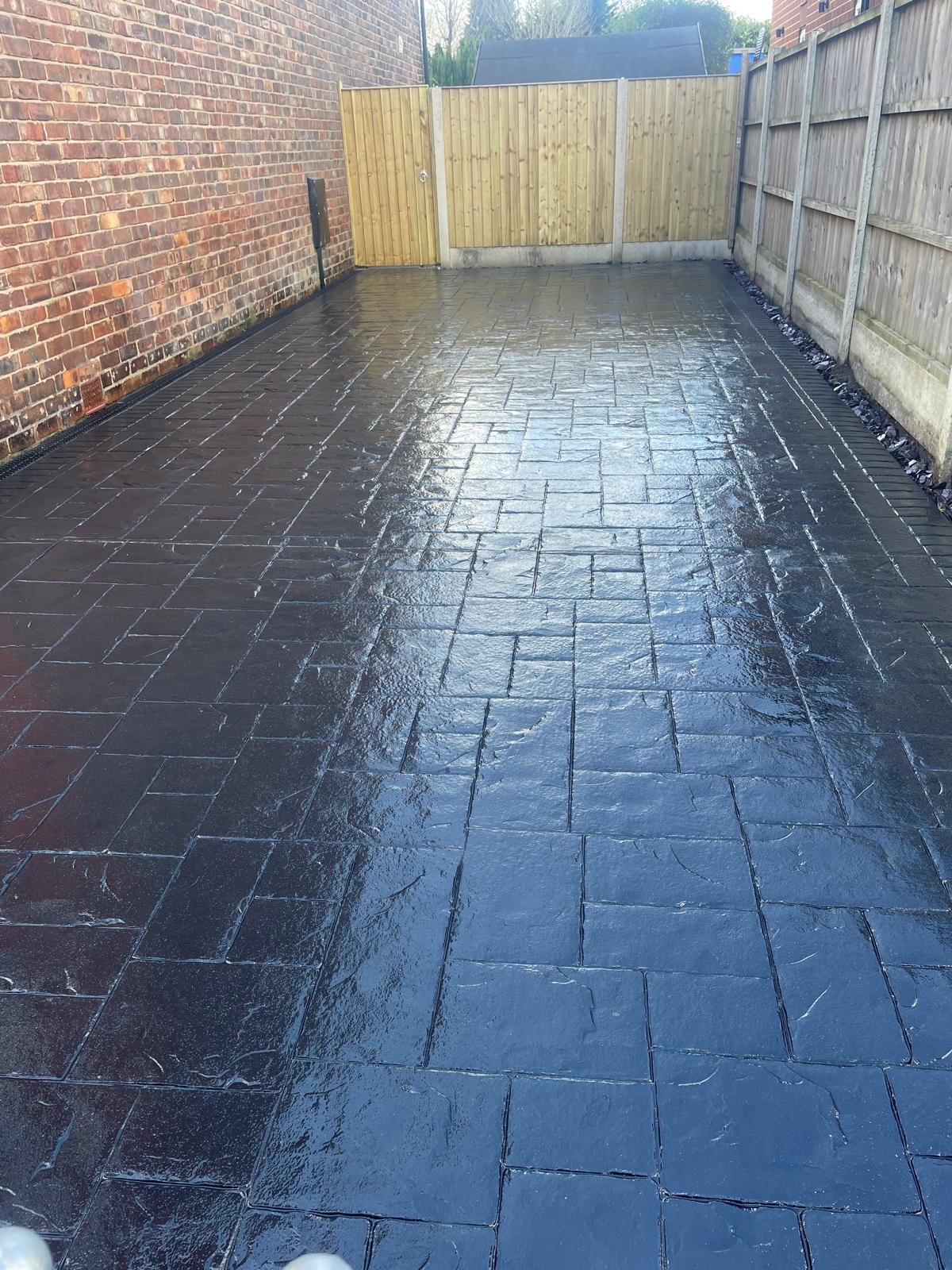 Long charcoal imprinted concrete driveway